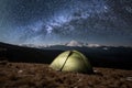 Night camping. Illuminated tourist tent under beautiful night sky full of stars and milky way Royalty Free Stock Photo