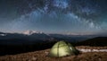 Night camping. Illuminated tourist tent under beautiful night sky full of stars and milky way Royalty Free Stock Photo