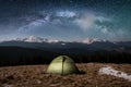 Night camping. Illuminated tourist tent under beautiful night sky full of stars and milky way Royalty Free Stock Photo