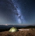 Night camping. Illuminated tourist tent under beautiful night sky full of stars and milky way Royalty Free Stock Photo