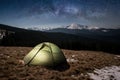 Night camping. Illuminated tourist tent under beautiful night sky full of stars and milky way Royalty Free Stock Photo