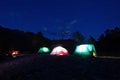 Night camping. Lighted tents and bonfire in the mountains under the night sky with stars. Royalty Free Stock Photo