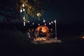 Night camping in the mountains. Group of friends hikers having a rest near tent with beer