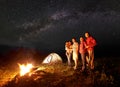 Tourist family with daughter having a rest in mountains at night under starry sky with Milky way Royalty Free Stock Photo