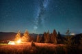 Night camping in mountains under starry sky with Milky way.