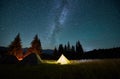 Night camping in mountains under starry sky with Milky way.