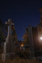 Night cemetery tomb stone and cross gothic style Halloween season time vertical photography with glare of light effect and vibrant Royalty Free Stock Photo