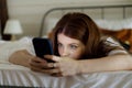 Night chat on smartphone. A young girl surfs the internet in bed, plays games or watches videos. Phone addiction