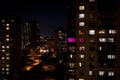 Night city landscape, many multi-colored windows on a black background. Horizontal frame Royalty Free Stock Photo