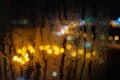 Night city raindrops through the glass, the light of cars and traffic lights, defocus, rain drops on car glass in rainy night Royalty Free Stock Photo