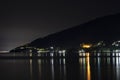 Night city in the reflection of the water of the sea. Night beach of pebbles Abkhazia Gagra. Black night, highlands, tourism, Royalty Free Stock Photo