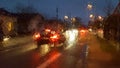 Night city road through windshield cars abstract background water drop on the glass lights and rain Royalty Free Stock Photo