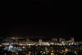 Night city skyline timelapse. Top aerial panoramic view of modern city from tower rooftop. Road junction traffic.