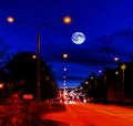 Night city sleeps ,lanterns on the road, cars lights blurry , blue sky and full moon with moonlight panorama