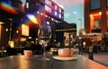 Night city street cafe cup of coffee and glass of wine on table modern and vintage houses lamp blurred light ubman life stile