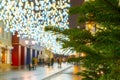 Night city street with people, new year and christmas eve. Christmas tree with garland and lantern