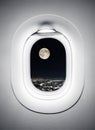 Night city under moon at airplane window Royalty Free Stock Photo