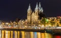 Night city view of Amsterdam canal and Basilica of Saint Nicholas, Holland, Netherlands. Royalty Free Stock Photo