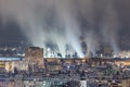 Night city view with buildings and a smoking industrial steel mill Royalty Free Stock Photo