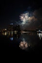 night cityscape in the distance with bright lighting over the water.