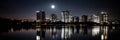 A city skyline lit up at night with a full moon in the sky, AI Royalty Free Stock Photo