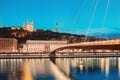 Night cityscape with illuminated Courthouse and red pedestrian bridge over Saone river. Panoramic blue hour landscape Royalty Free Stock Photo