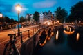 Night cityview of Famous Keizersgracht Emperor`s canal in Amsterdam, tranquil scene with street lantern, illuminated bridge at