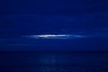 Night Clouds Over the Water. The Light from the Full Blue Moon Breaks Brightly Through the Clouds and Rises over the Calm Ocean, Royalty Free Stock Photo