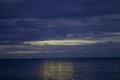 Night Clouds Over the Water. The Light from the Full Blue Moon Breaks Brightly Through the Clouds and Rises over the Calm Ocean, Royalty Free Stock Photo