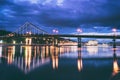 Night european city in colorful lights and reflection in water, Kiev, Ukraine. Pedestrian bridge across the Dnieper river Royalty Free Stock Photo