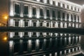 Night foggy city of Voronezh. Symmetrical reflection of house in pool