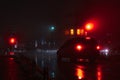 Night foggy street in the city. The car stops at a red traffic light. Soft focus. Royalty Free Stock Photo