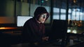 Night hacker cracking databases at evening closeup. Scammer commits fraud AI Royalty Free Stock Photo