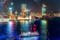 Night Hong Kong cityscape with city lights and cruise boat viewed from the Observation Wheel at Victoria Harbour waterfront Royalty Free Stock Photo