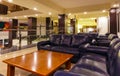 Night interior of the resort European hotel, illuminated staircase with transparent railing, leather sofas with tables for