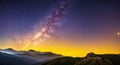 Night landscape with colorful Milky Way and yellow light at mountains. Starry sky with hills at summer. Beautiful Universe Royalty Free Stock Photo