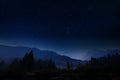 Night landscape with dark sky and stars in Slovenia, nature in Europe. Foggy Triglav Alps with forest, travel in Slovenia.