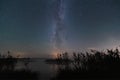 Night landscape in Estonia, the milky way and the starry sky over the lake set in autumn Royalty Free Stock Photo