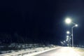 Night landscape with illuminated road and forest