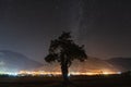 Milky Way and tree in the mountain. Old oak tree growing  in field and mountain in background. Night landscape and sky full of sta Royalty Free Stock Photo