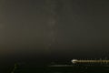 Small pleasure boat moored to a pier near the sea coast. Starry night sky over the sea Royalty Free Stock Photo