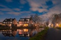 Night landscape with starry sky in the Dutch village of Streefkerk. Houses with bright light reflecting in the shine of the water