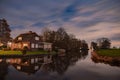 Night landscape with starry sky in the Dutch village of Streefkerk. Houses with bright light reflecting in the shine of the water