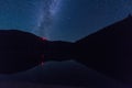 Night landscape with starry sky and Milky Way during Perseid meteor shower over the alpine lake Synevyr in Carpathian mountains Royalty Free Stock Photo