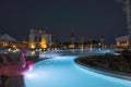 Night landscape view of hotel area. Lighting, trees, swimming pool modern buildings on dark sky background. Royalty Free Stock Photo