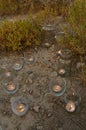 Night light candles burning in upcycled glass jars in desert