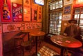 Night light inside old bar with beer aadvertising posters and man drinking alcohol