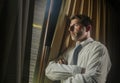 Night light office portrait of business man working late looking worried through window thoughtful and pensive feeling sad and