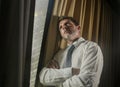 Night light office portrait of business man working late looking worried through window thoughtful and pensive feeling sad and