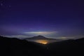 Night light of Randazzo town glowing under Etna Mount and sky full of stars from Nebrodi Park Royalty Free Stock Photo